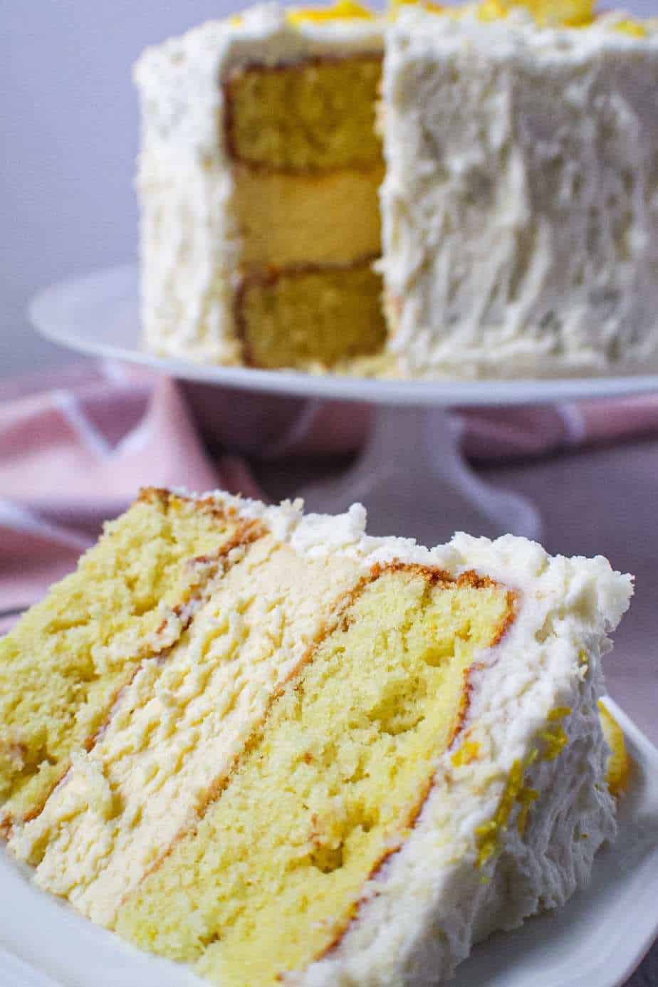 side shot of lemon cheesecake layer cake on cake stand