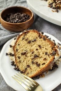 chocolate chip pound cake with cookie dough frosting on a small white plate.