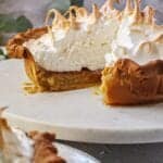 maple chess pie with meringue peaks on top sitting on white cake stand