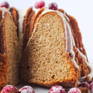 Spiced Bundt cake with maple cream cheese glaze on a cake plate.