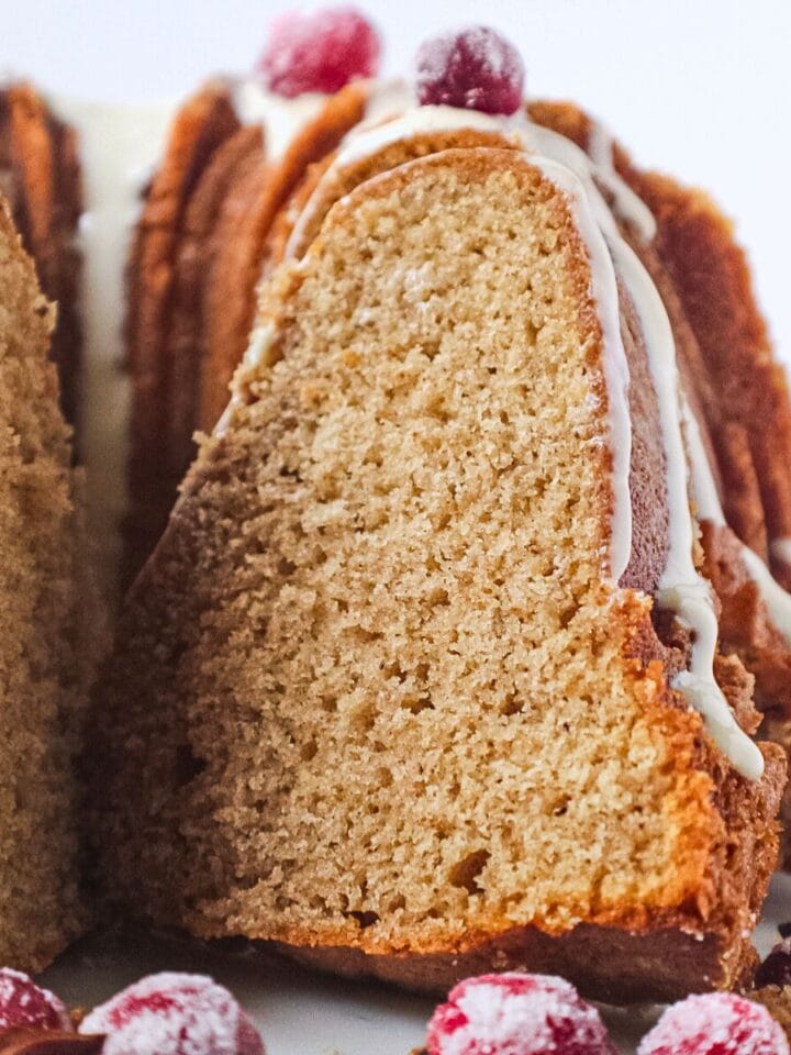 Spiced Bundt cake with maple cream cheese glaze on a cake plate.