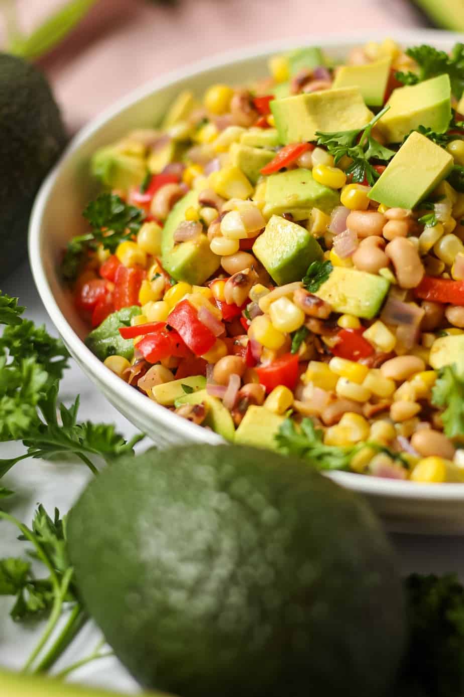 side angle shot of avocado and black-eyed pea succotash in white bowl 