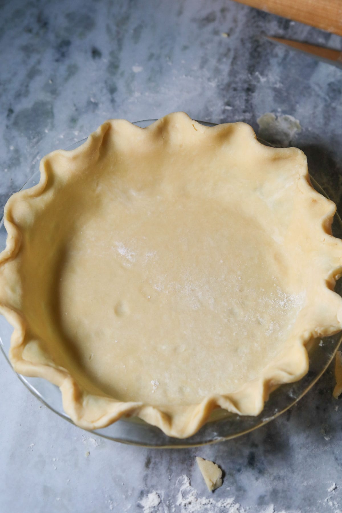 Homemade sweet potato pie crust in a pie plate.