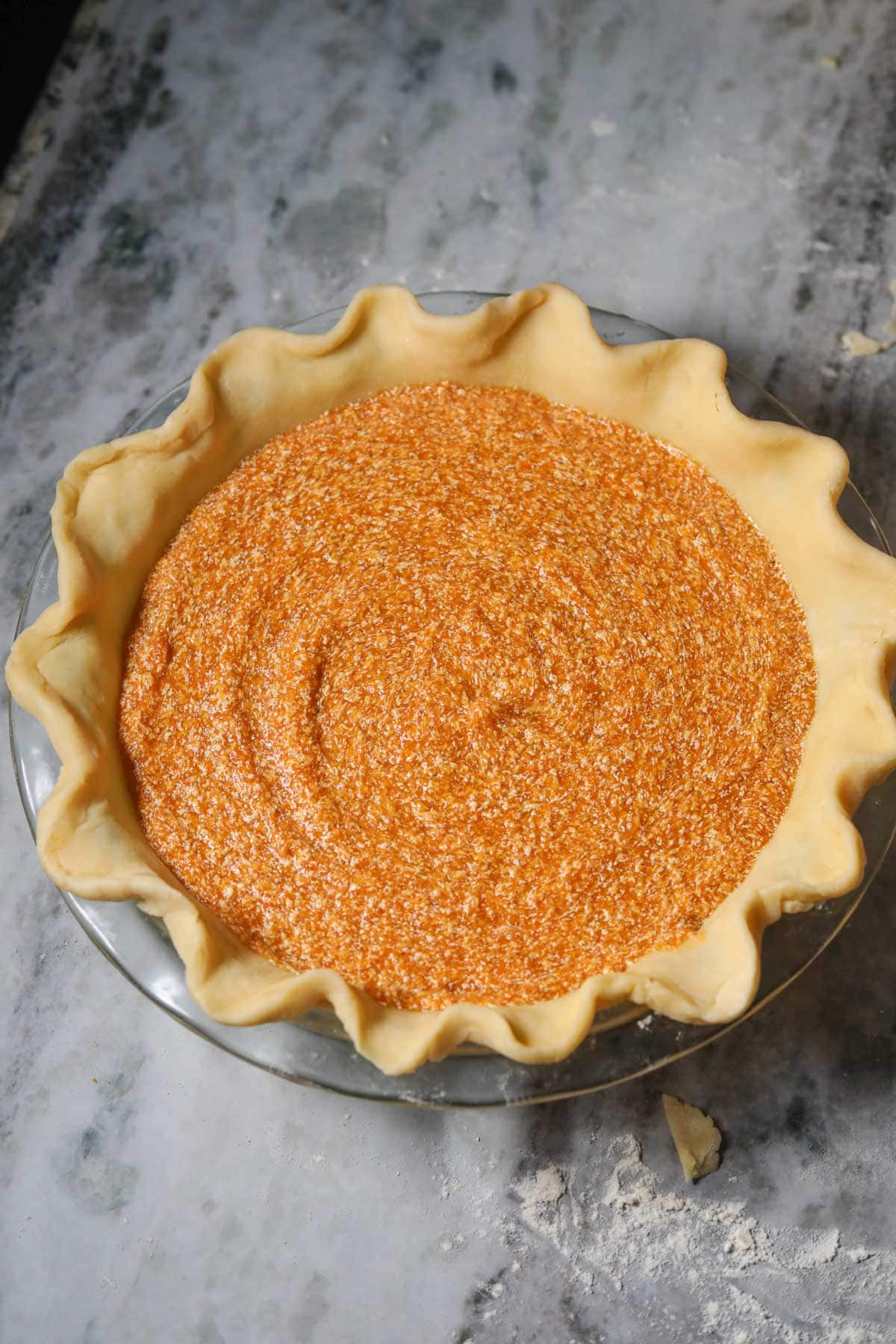 Unbaked sweet potato pie on a table top.