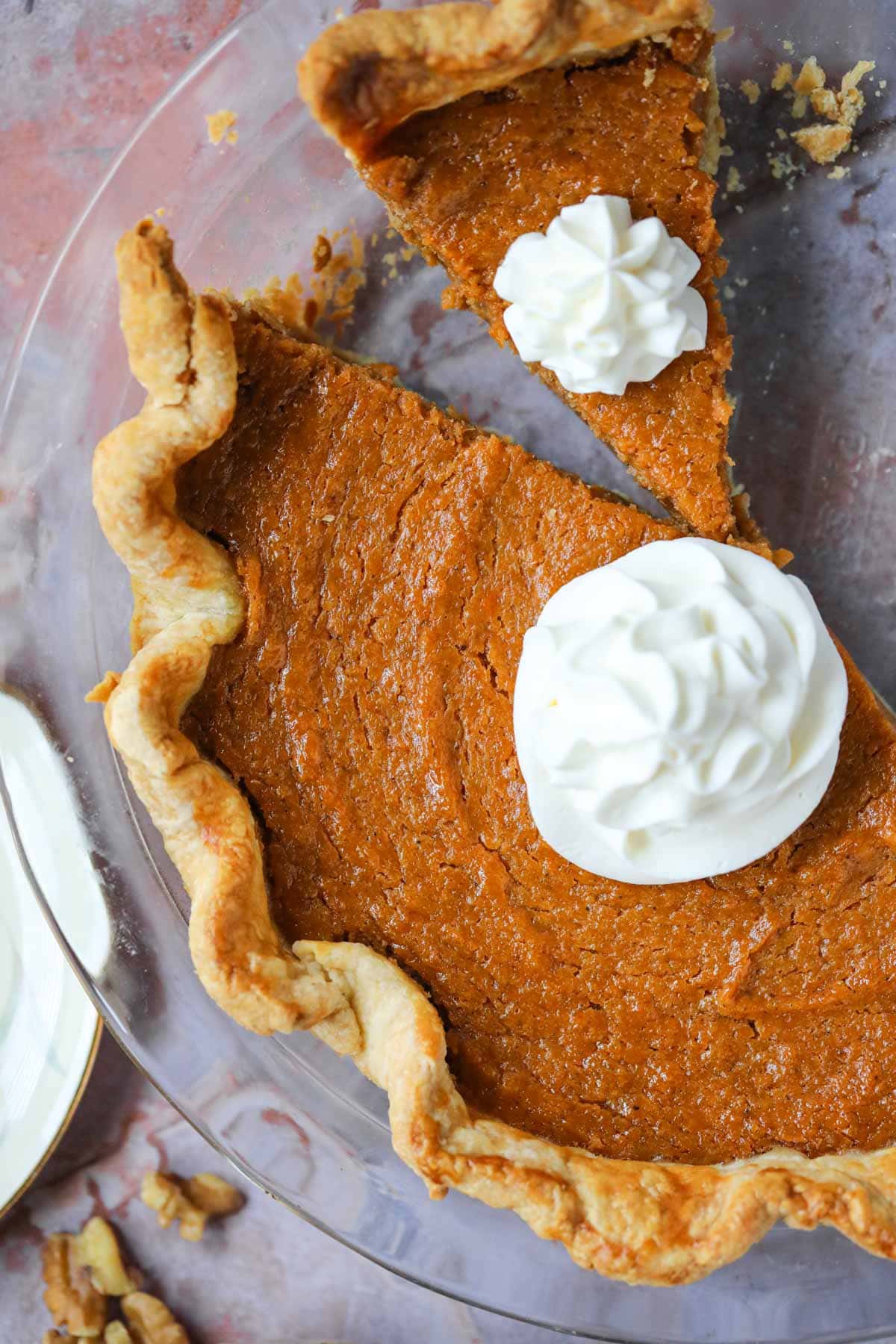 Southern sweet potato pie in a glass pie dish sitting on a copper tile table top.