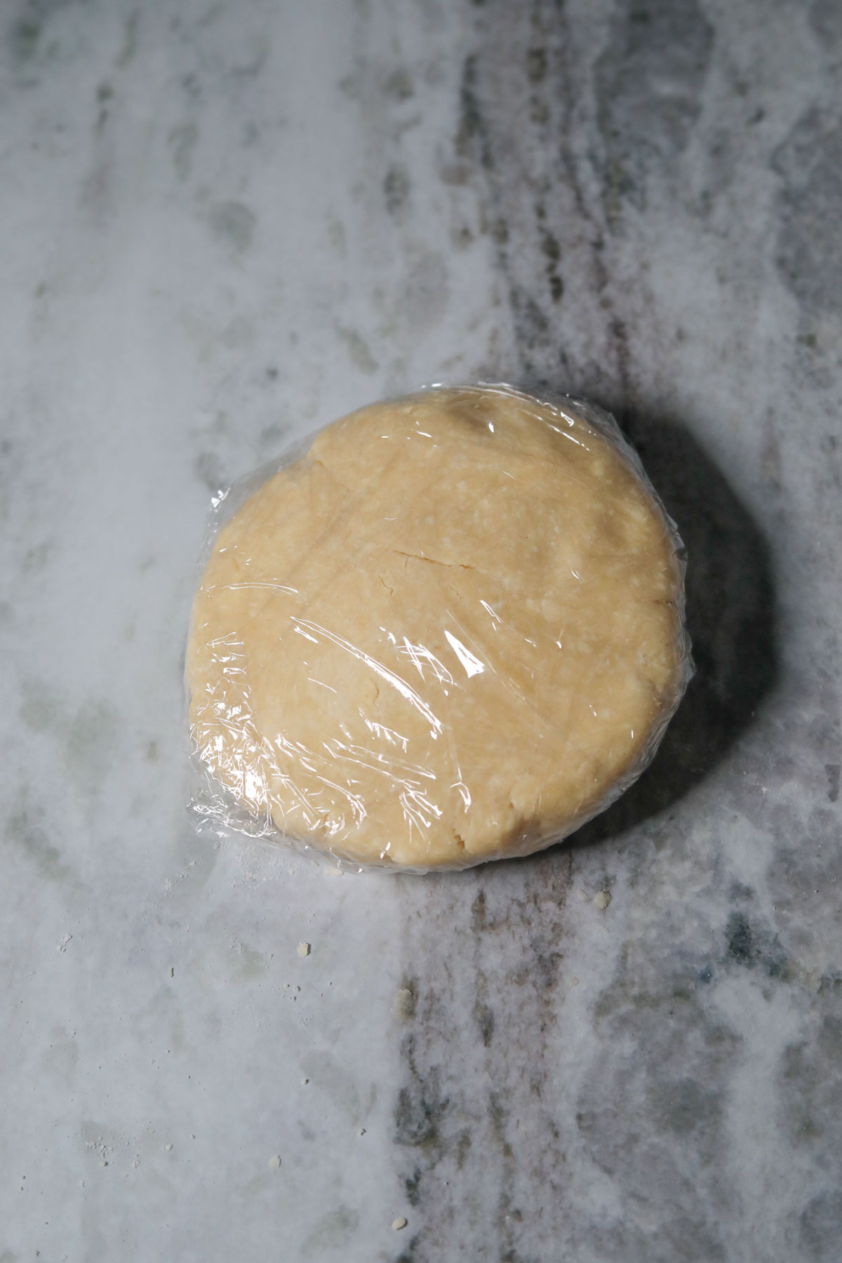 Homemade pie dough for making soup potato pie wrapped in plastic wrap.