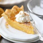 A slice of buttermilk pie on a white plate.