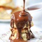 Chocolate gravy being poured over buttermilk biscuits.