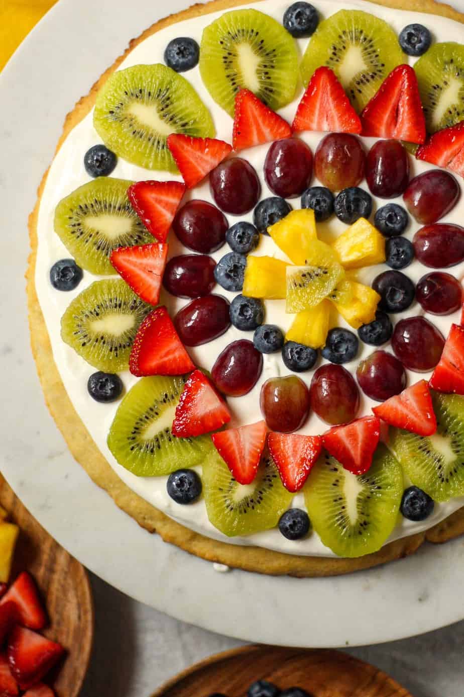 overhead shot of gluten=free fruit pizza on cake stand