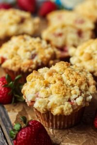 side shot of strawberry crumble muffins on parchment paper