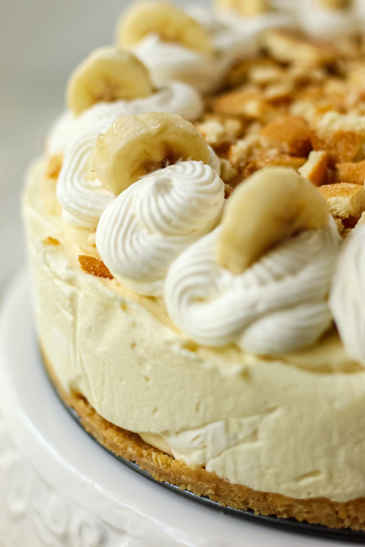 close up shot of banana pudding icebox pie on white cake stand