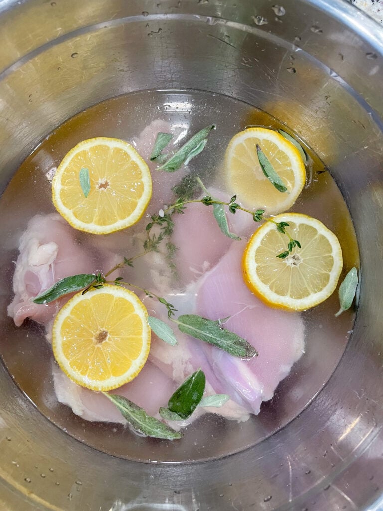 overhead shot of chicken soaking in brine in bowl