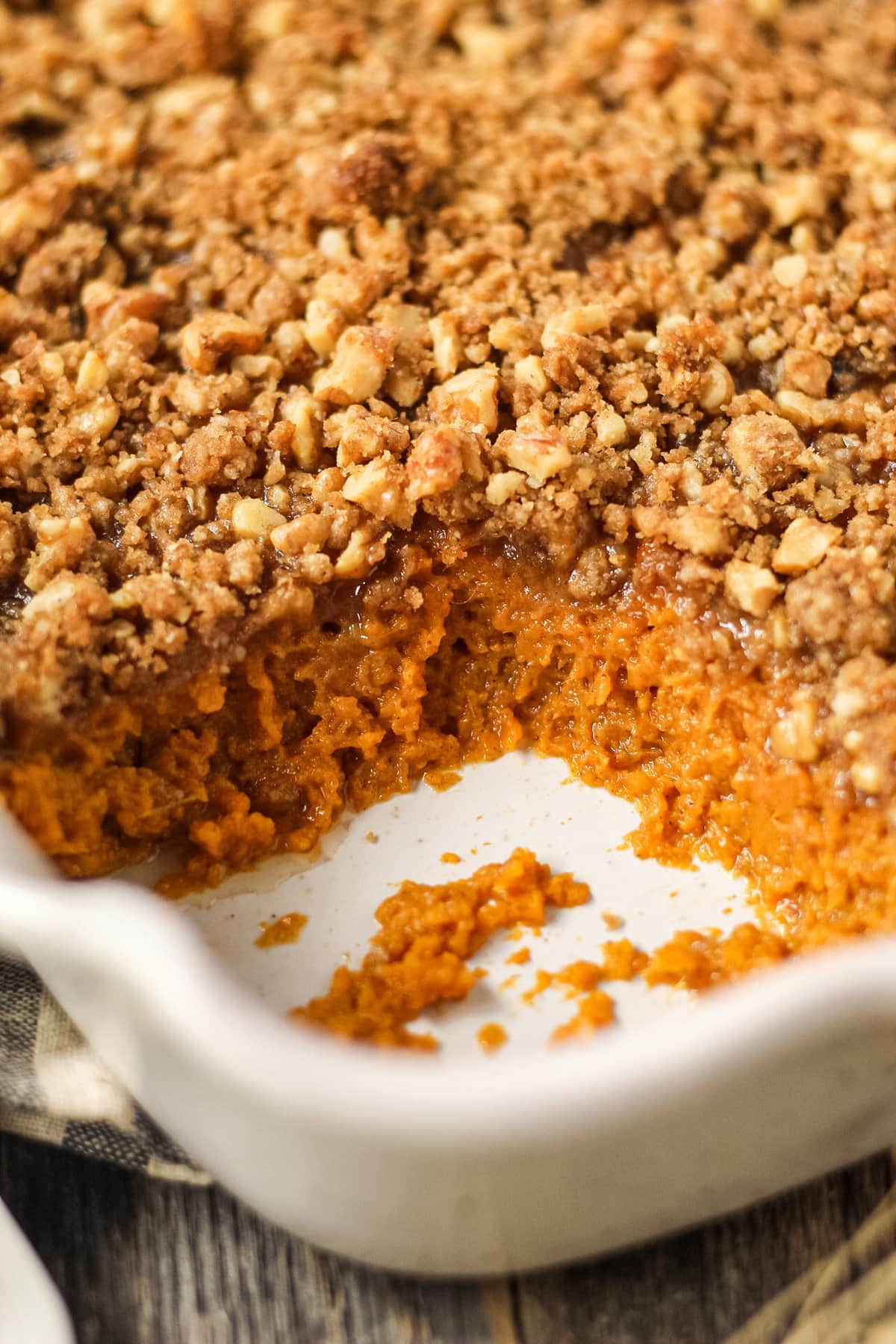 close up shot of maple walnut sweet potato casserole section wher a serving has been removed.