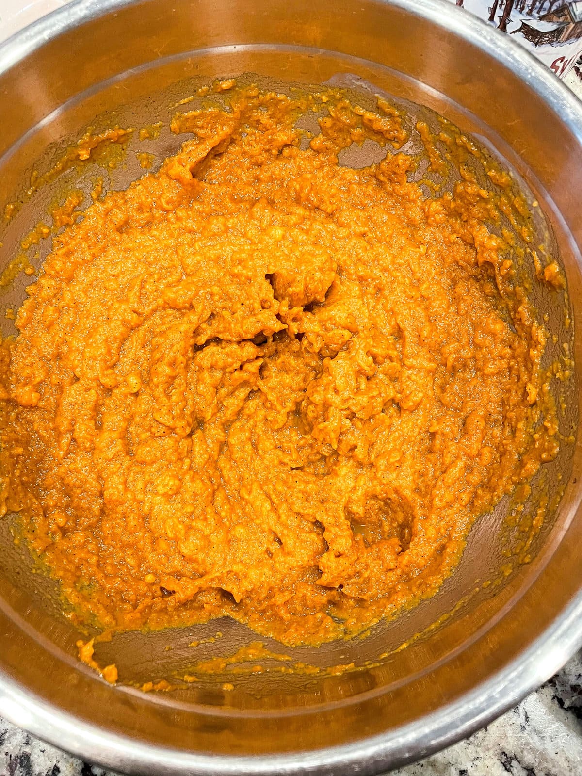 overhead shot of mashed sweet potatoes in a mixing bowl.