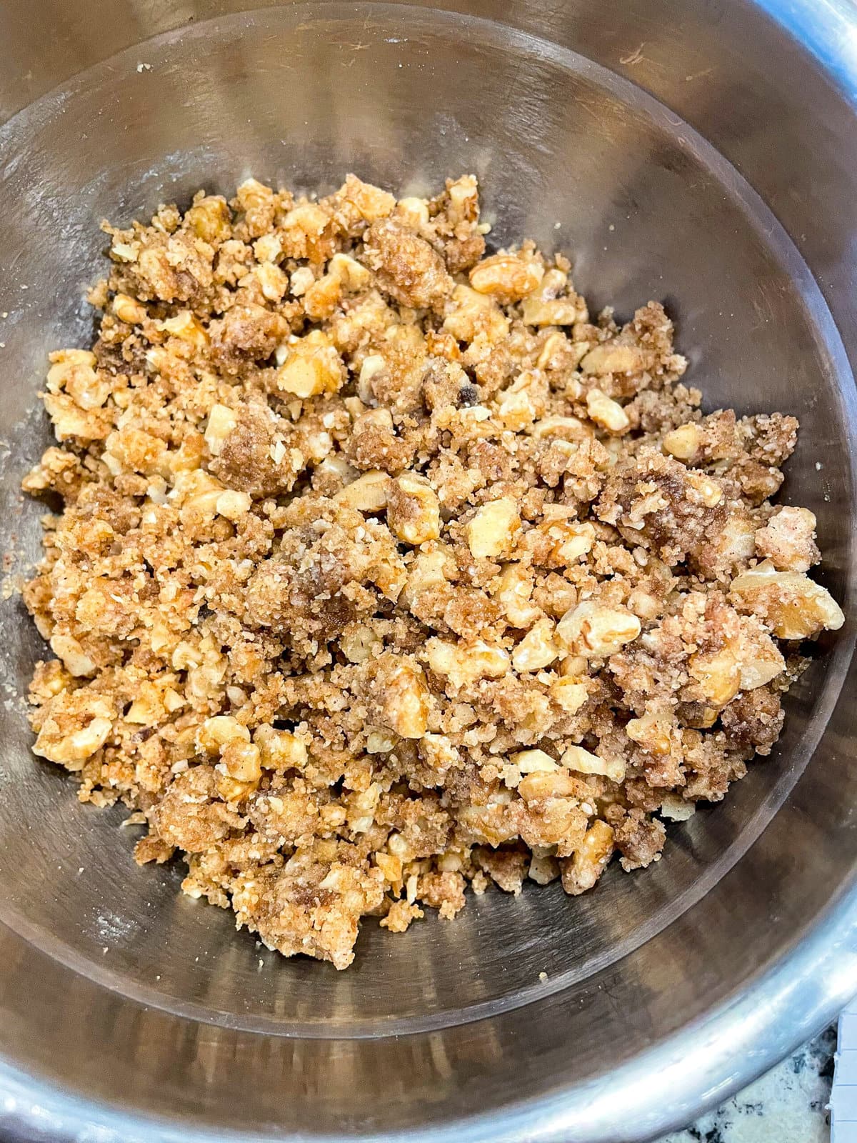 overhead shot of walnut streusel topping in a mixing bowl.