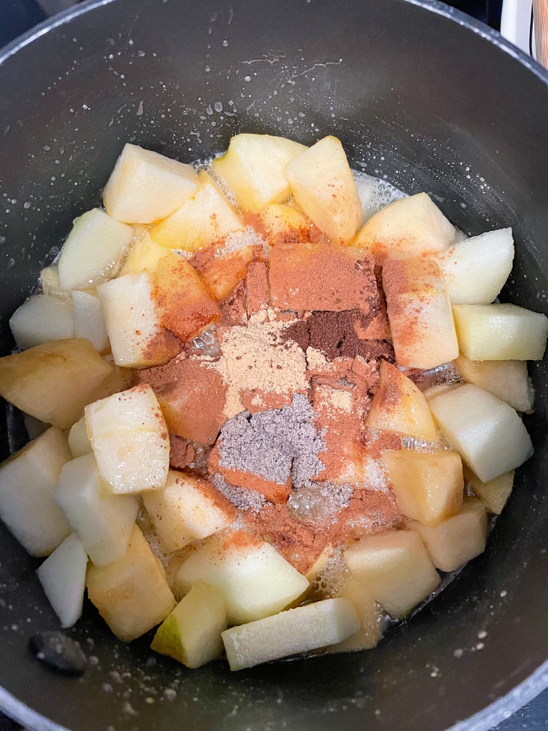 overhead shot of apples, sugar, an spices in pan for jam