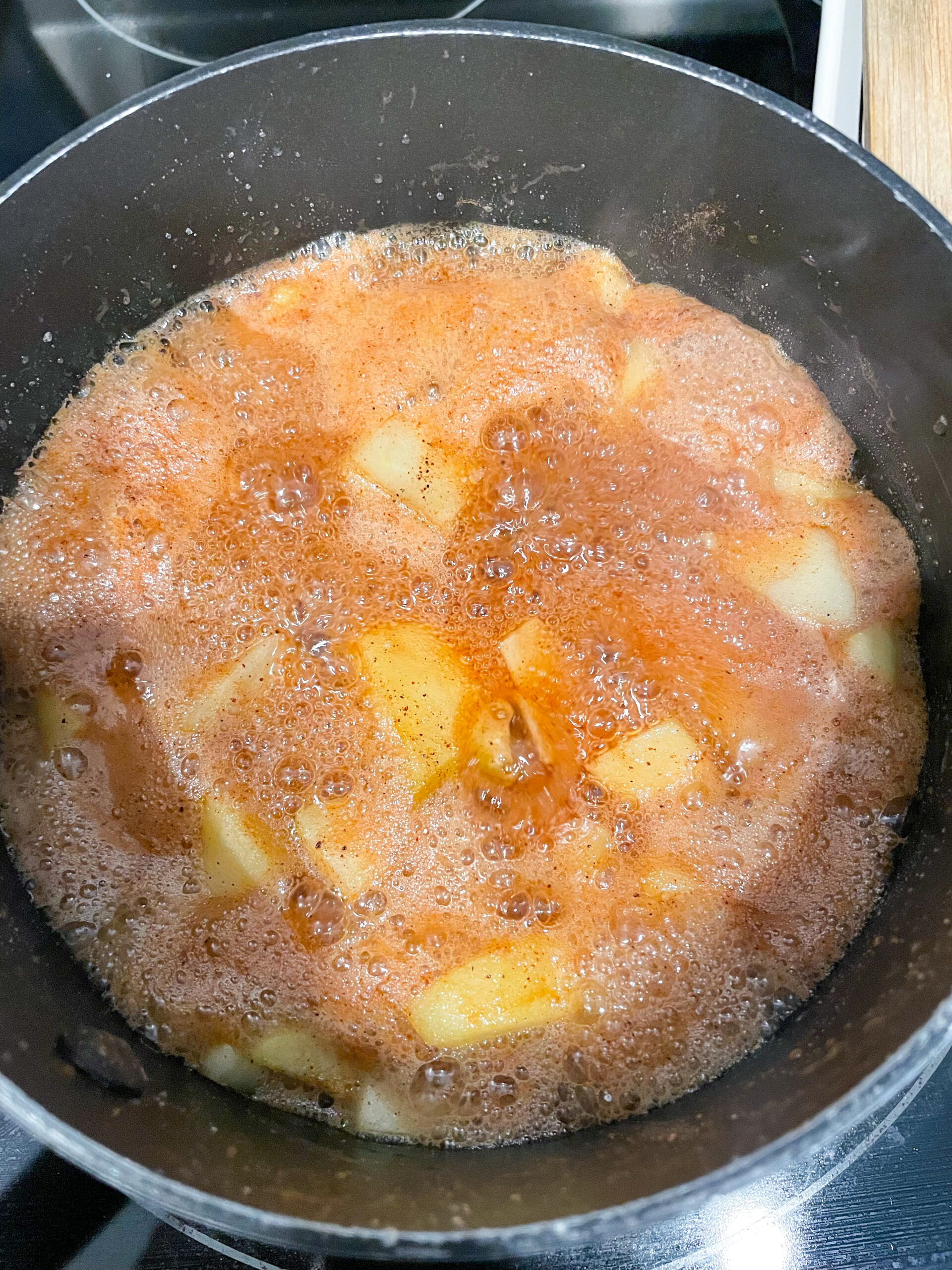 overhead shot of apple jam boiling in saucepan.