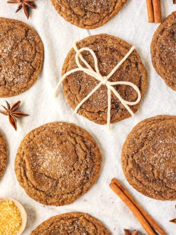 overhead shot of chewy chai spiced molasses cookies on a white linen.