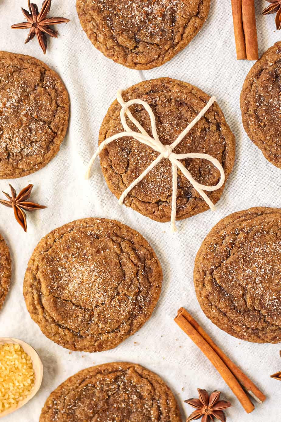 overhead shot of chewy chai spiced molasses cookies on a white linen.