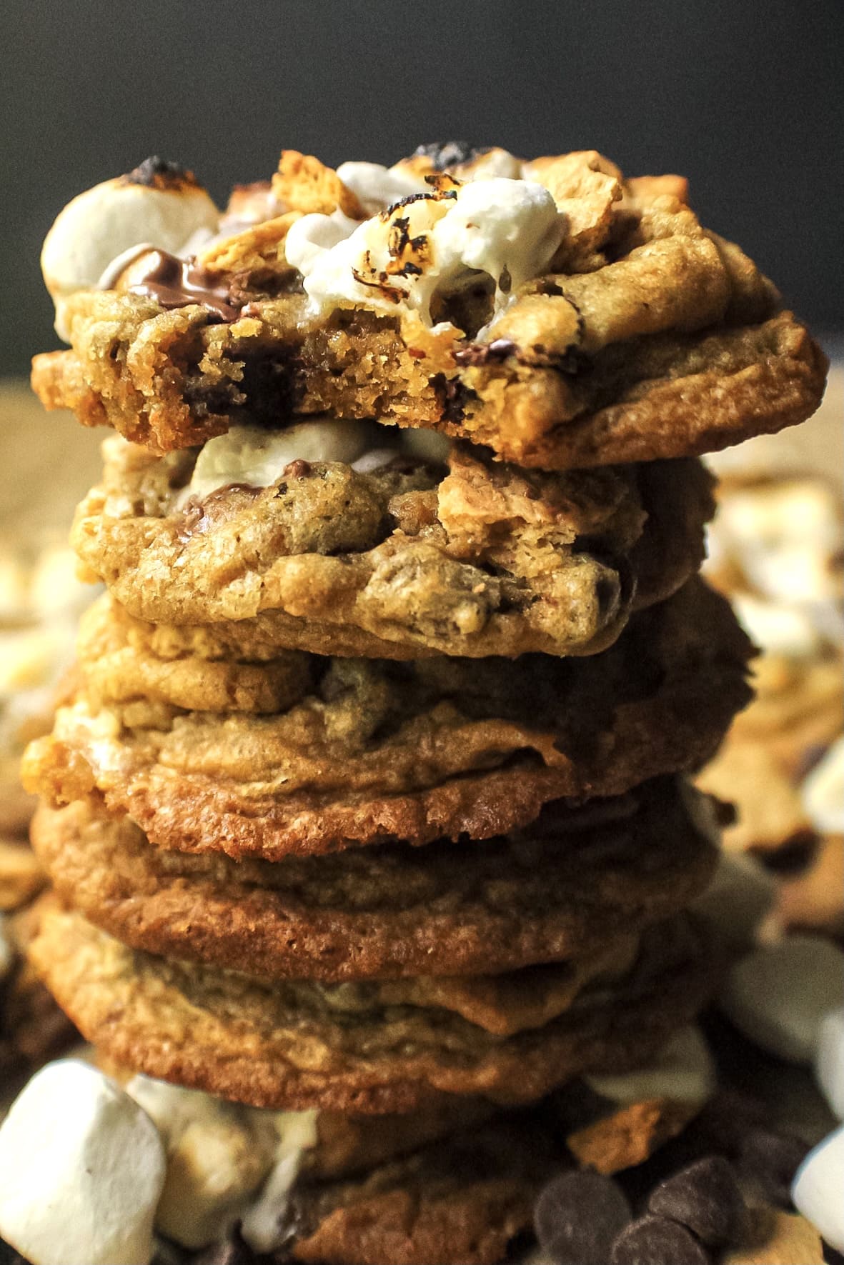 side angle shot of a stack of s'mores cookies on parchment paper.