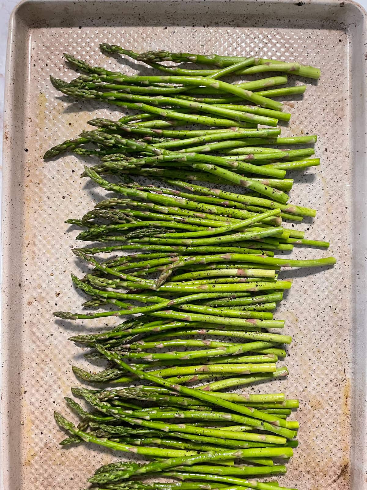 asparagus on sheet pan with salt and pepper