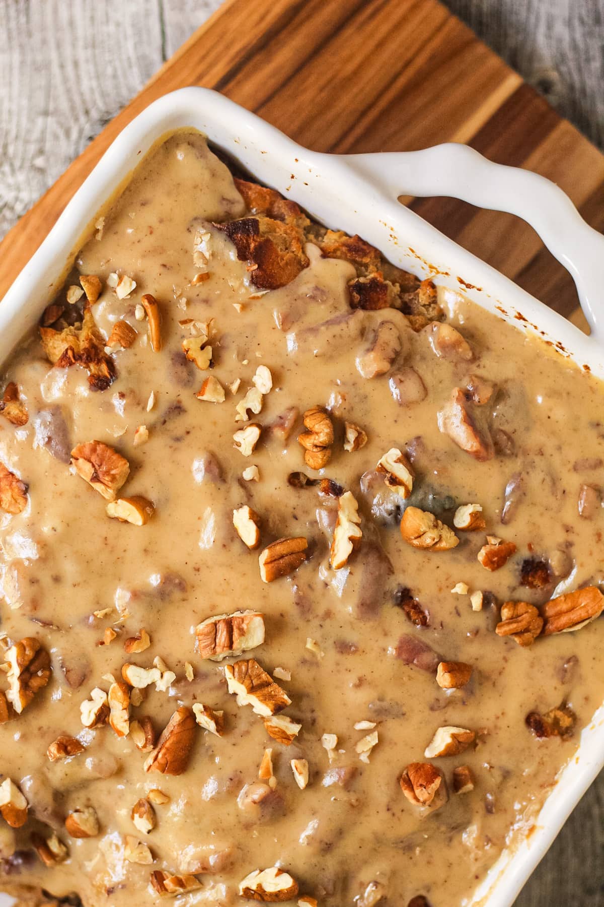 hummingbird bread pudding with praline sauce in a white baking dish