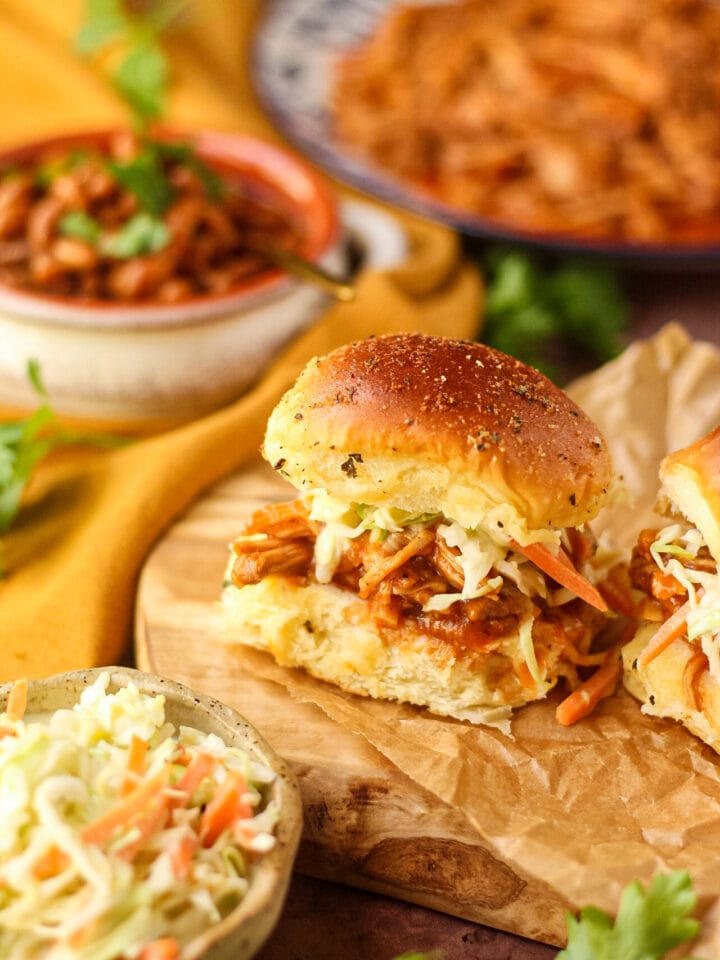 Barbecue pulled chicken sliders with southern coleslaw on a wooden cutting board