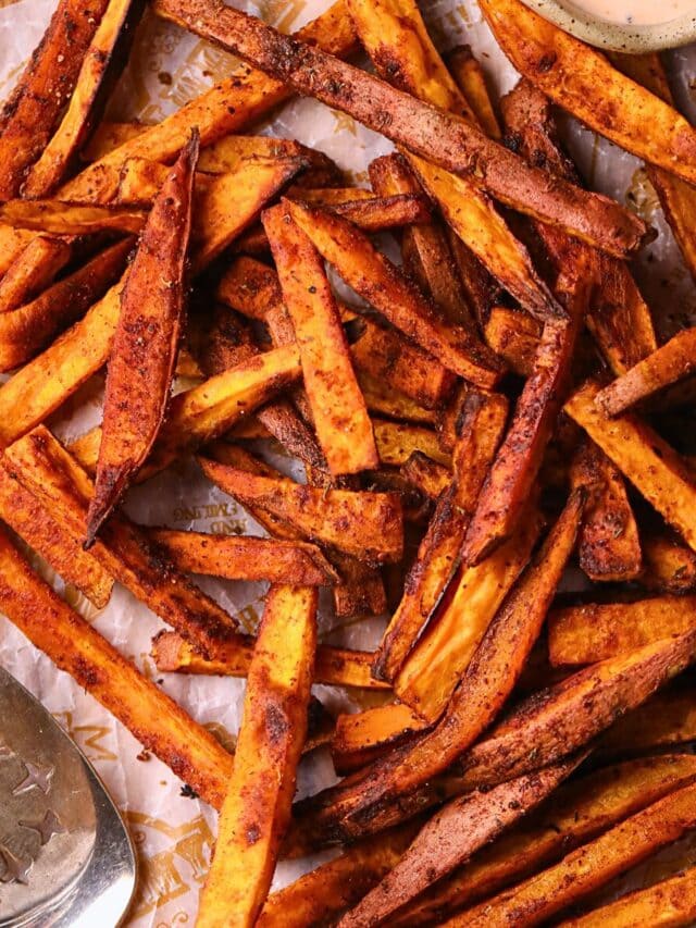Cajun oven baked sweet potato fries on a wooden cutting board.