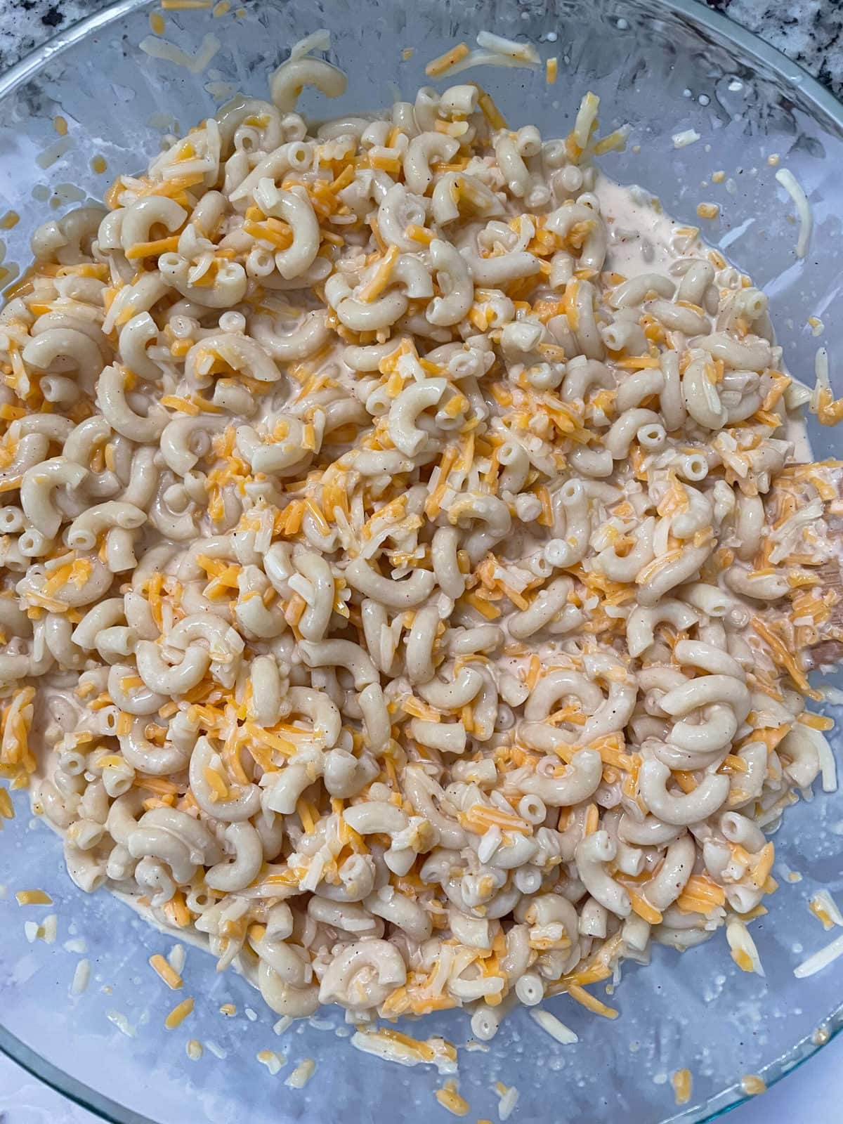 milk, cheese, and macaroni mixture in a glass bowl