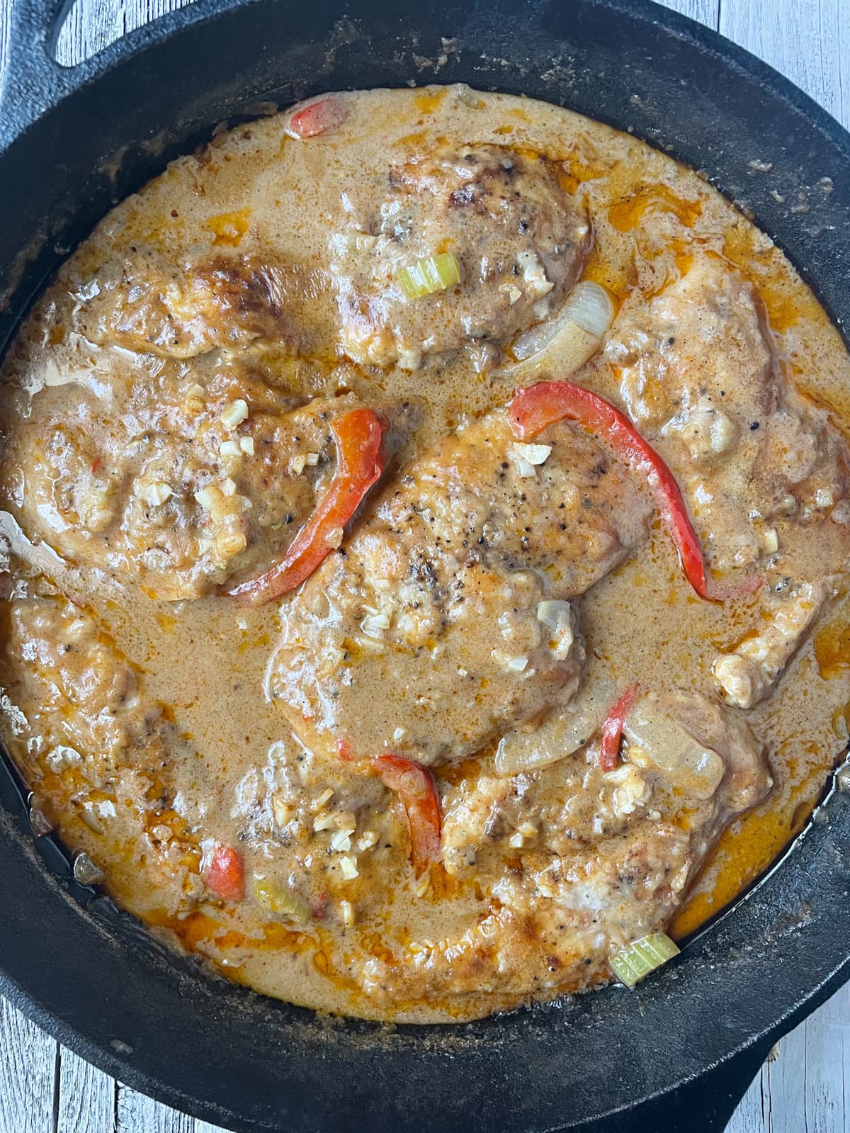 cajun smothered chicken cooked in skillet.