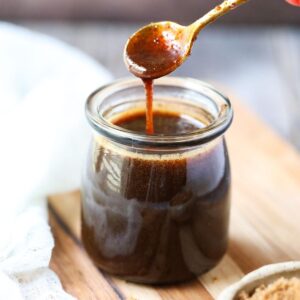 brown sugar glaze dripping from spoon into a glass jar.