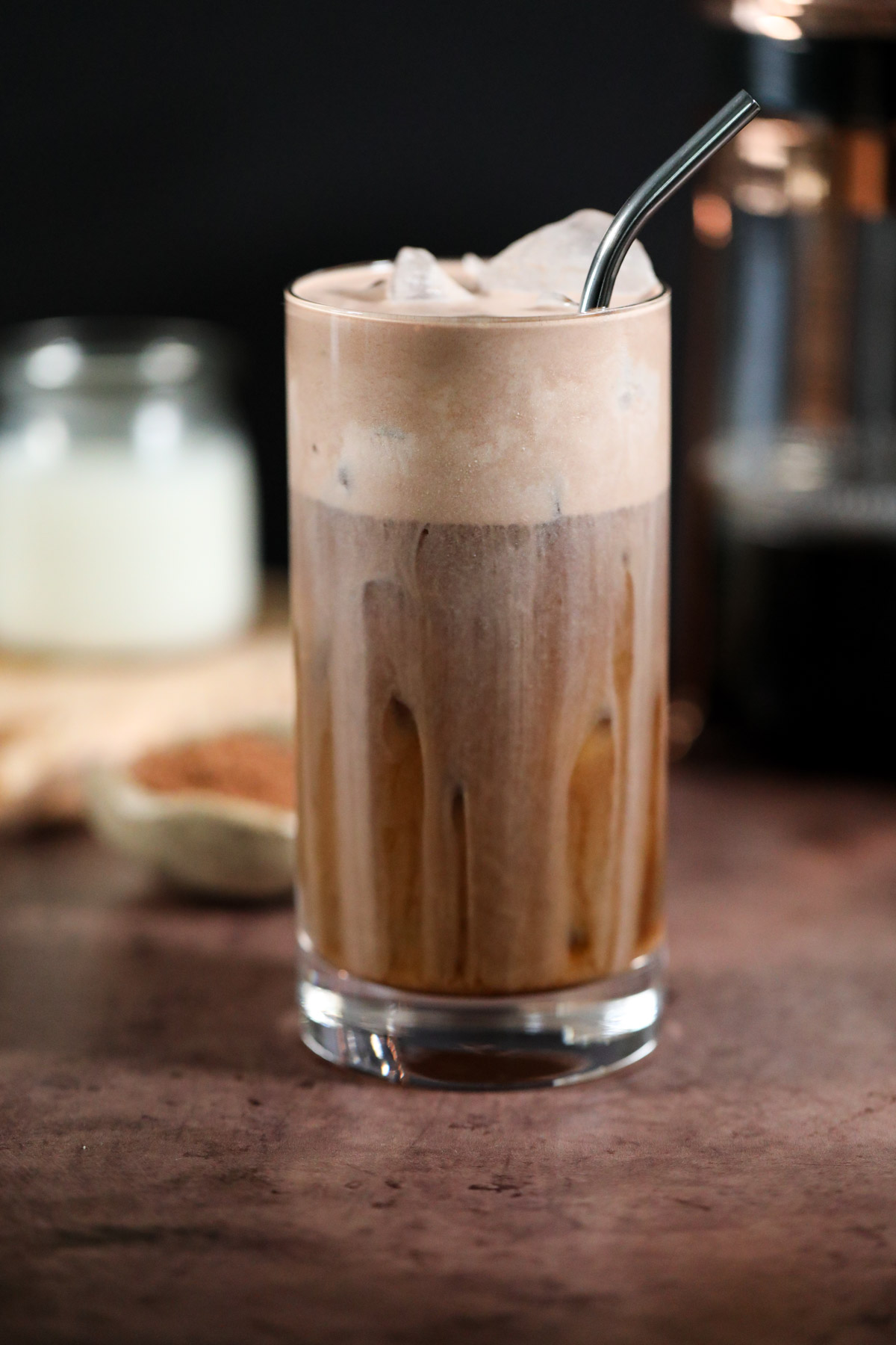chocolate cream cold brew in a glass on a brown surface.