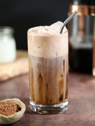 chocolate cream cold brew in a glass on a brown surface.