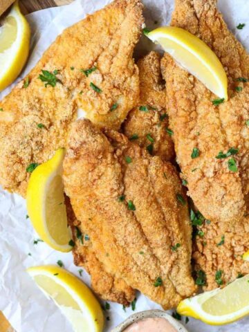 southern oven fried catfish on a wooden cutting board.