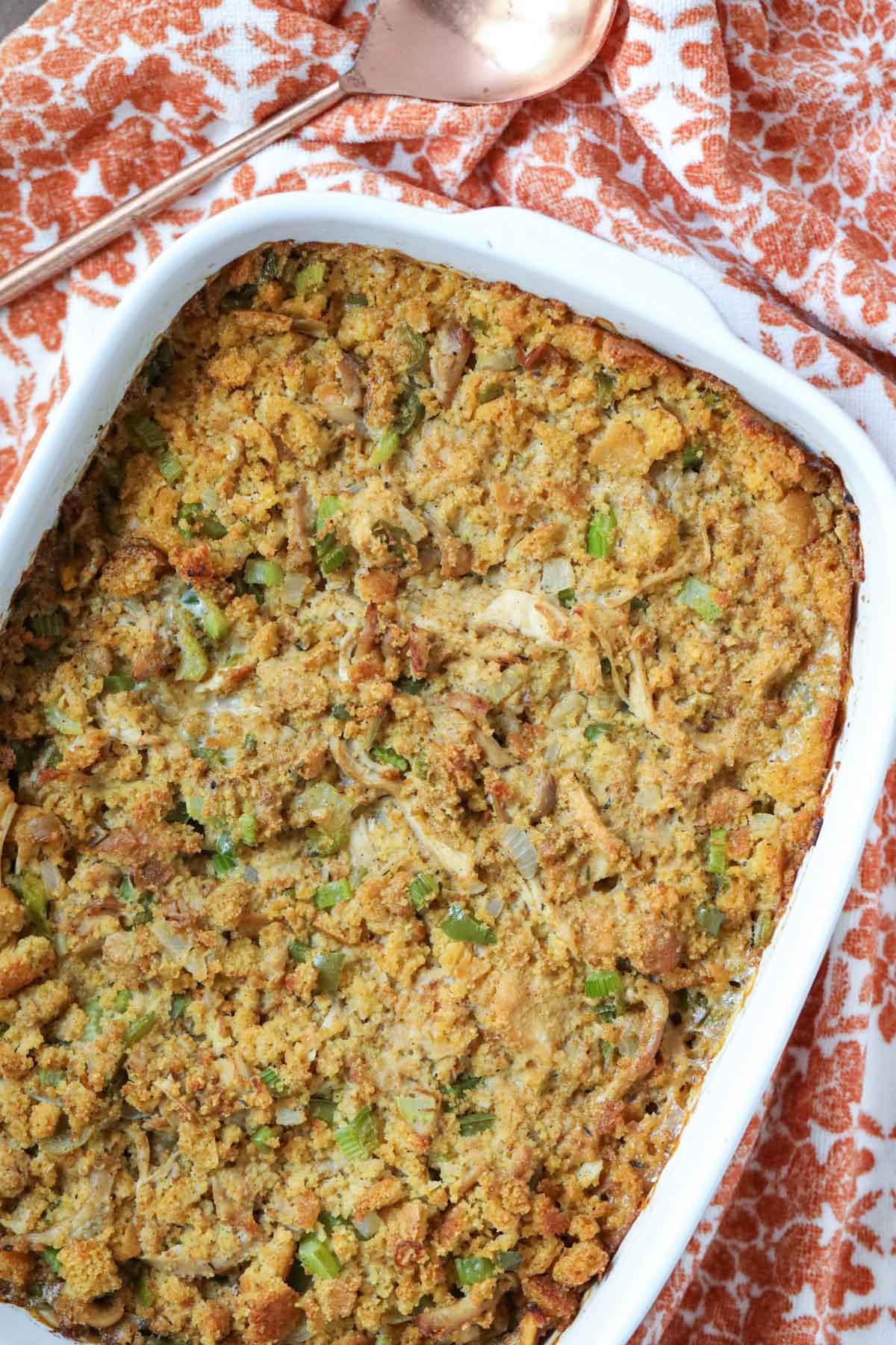 southern cornbread dressing in a white baking dish with an orange and white linen underneath.