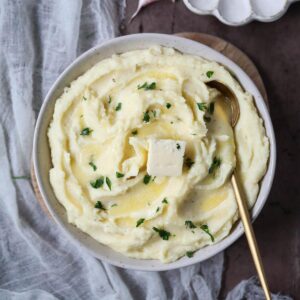 creamy garlic mashed potatoes in a white bowl.