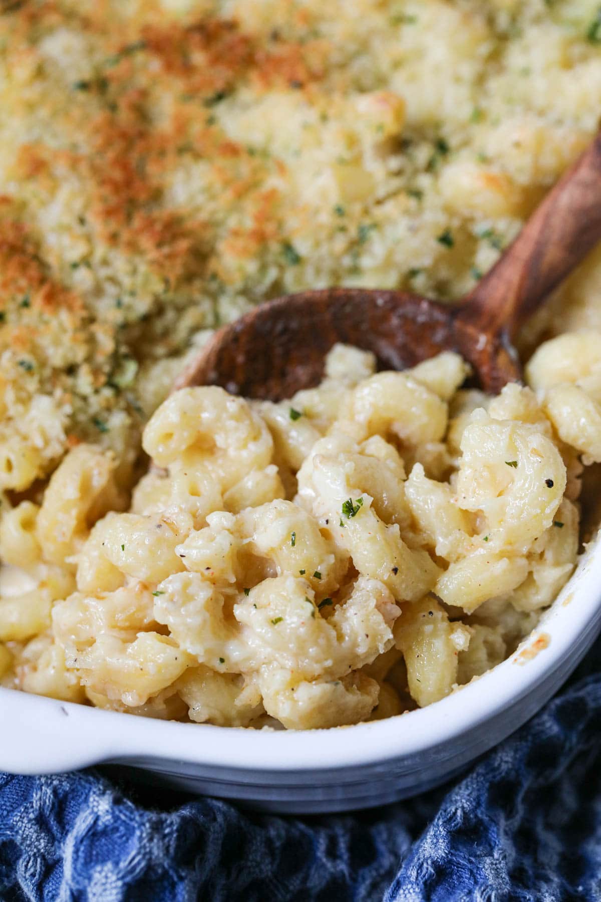 smoked gouda mac and cheese in a white baking dish with a blue linen underneath.