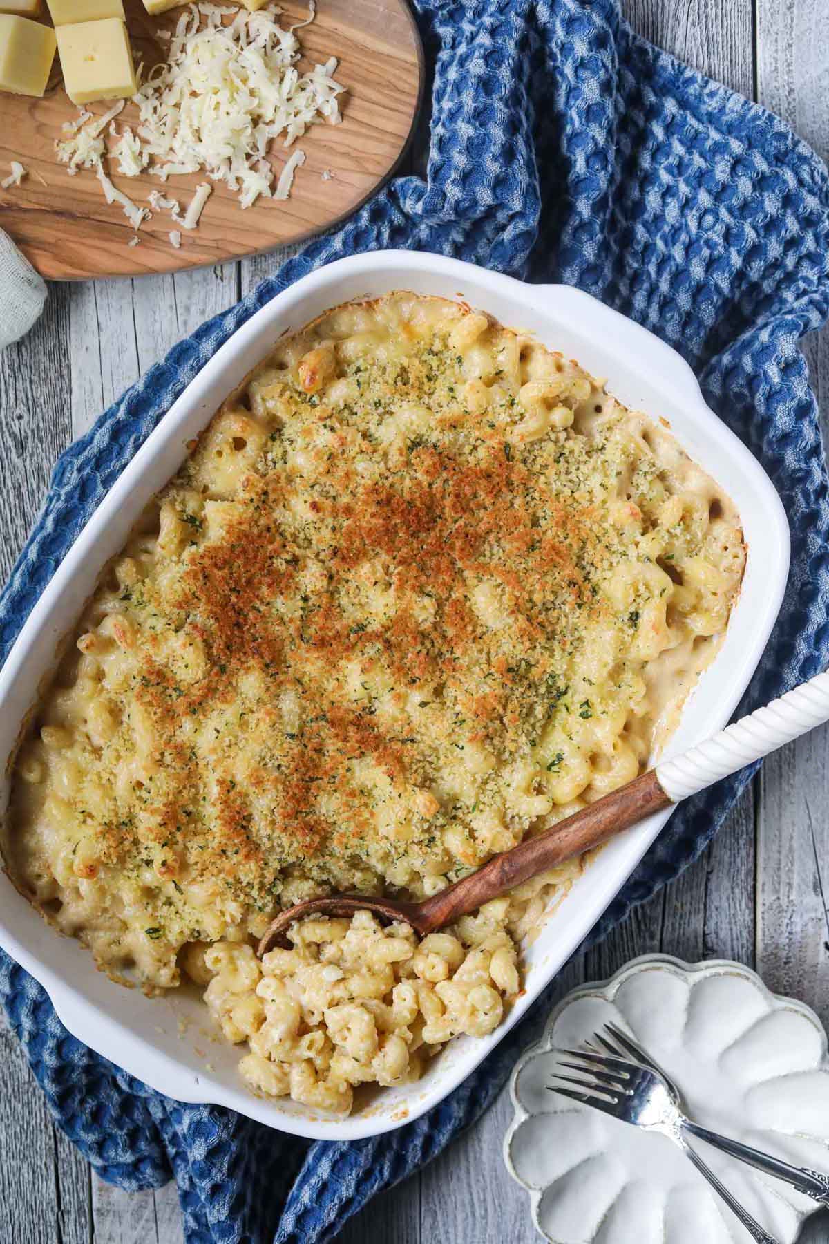 smoked gouda mac and cheese in a white baking dish with a blue linen underneath.