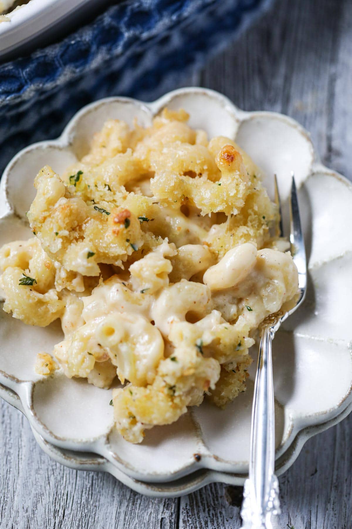 smoked gouda mac and cheese on a white plate with a sliver fork.