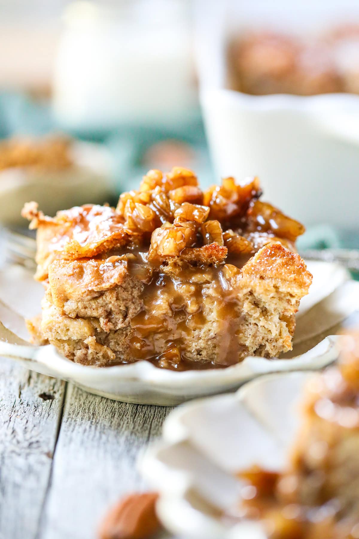 Small serving of bread pudding with maple praline sauce on a small dessert plate.