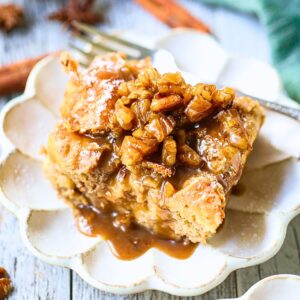 Small serving of bread pudding with maple praline sauce on a small dessert plate.