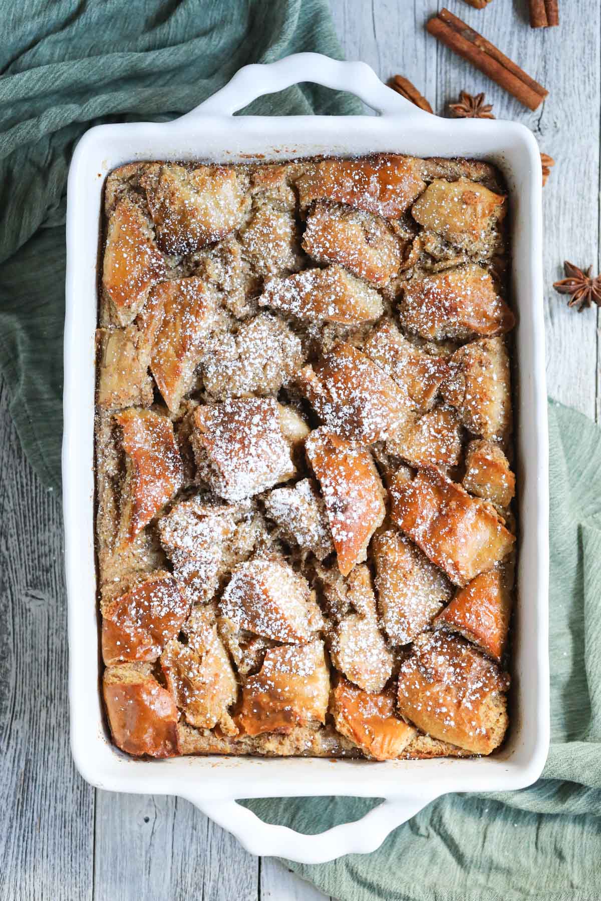 bread pudding in a white baking dish with a green linen underneath.