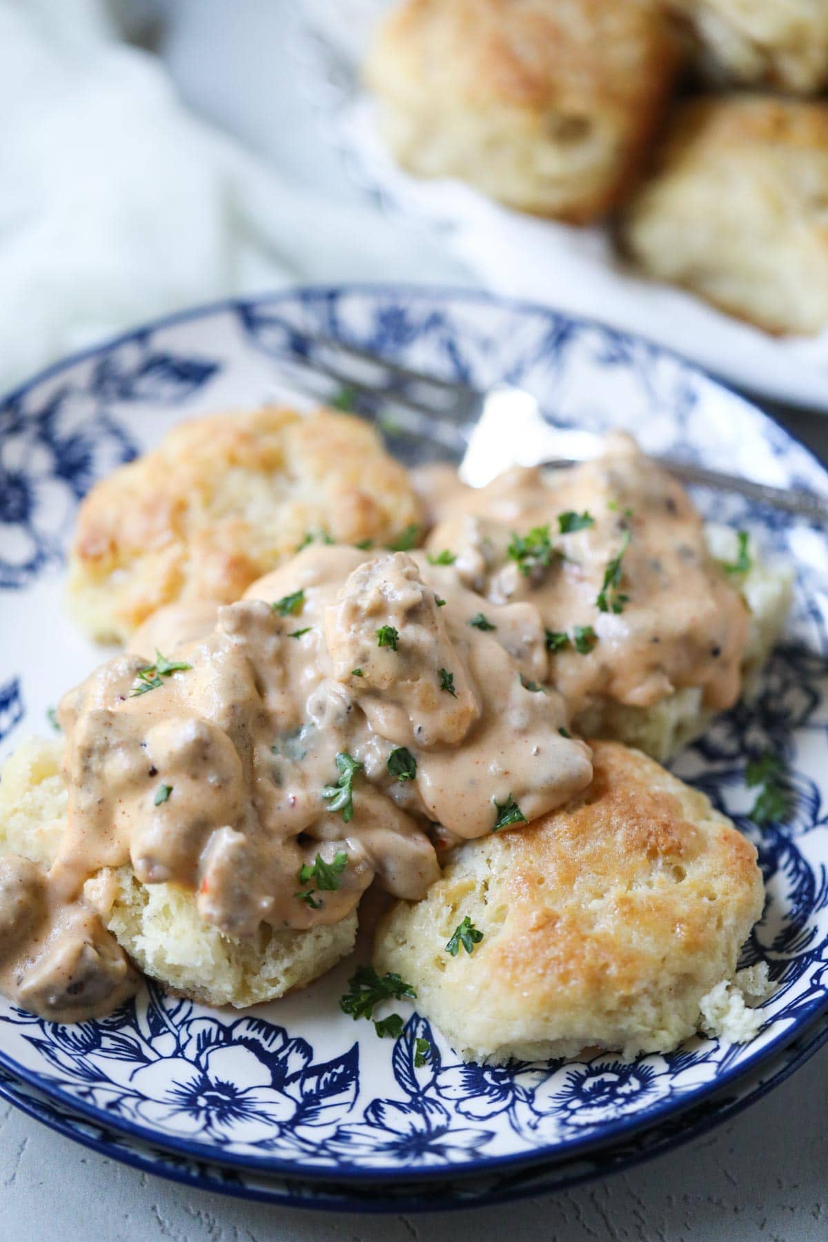 biscuits and gravy on blue and white plate.