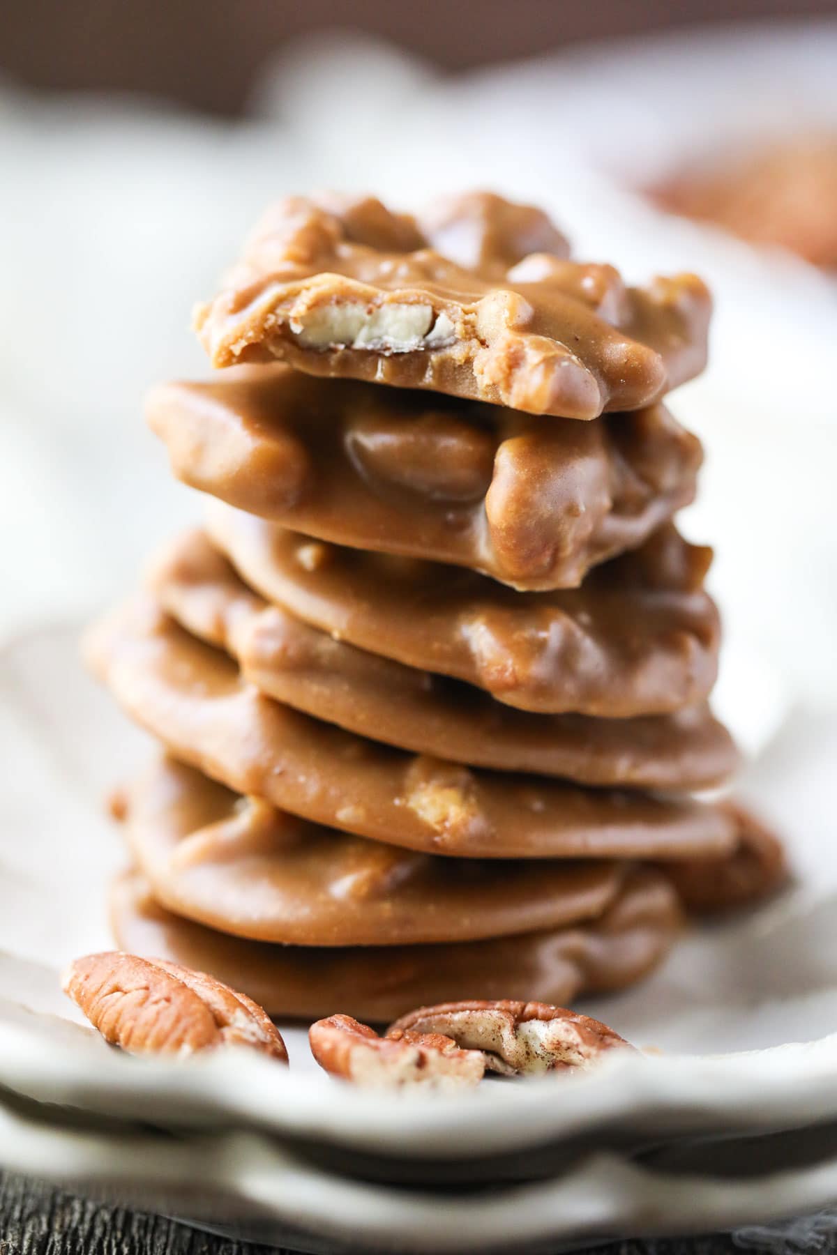 southern pecan pralines stacked on a white plate.