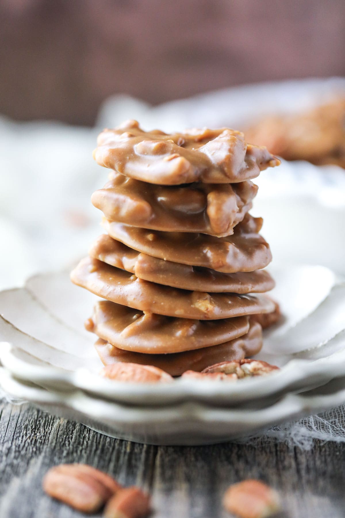 southern pecan pralines stacked on a white plate.