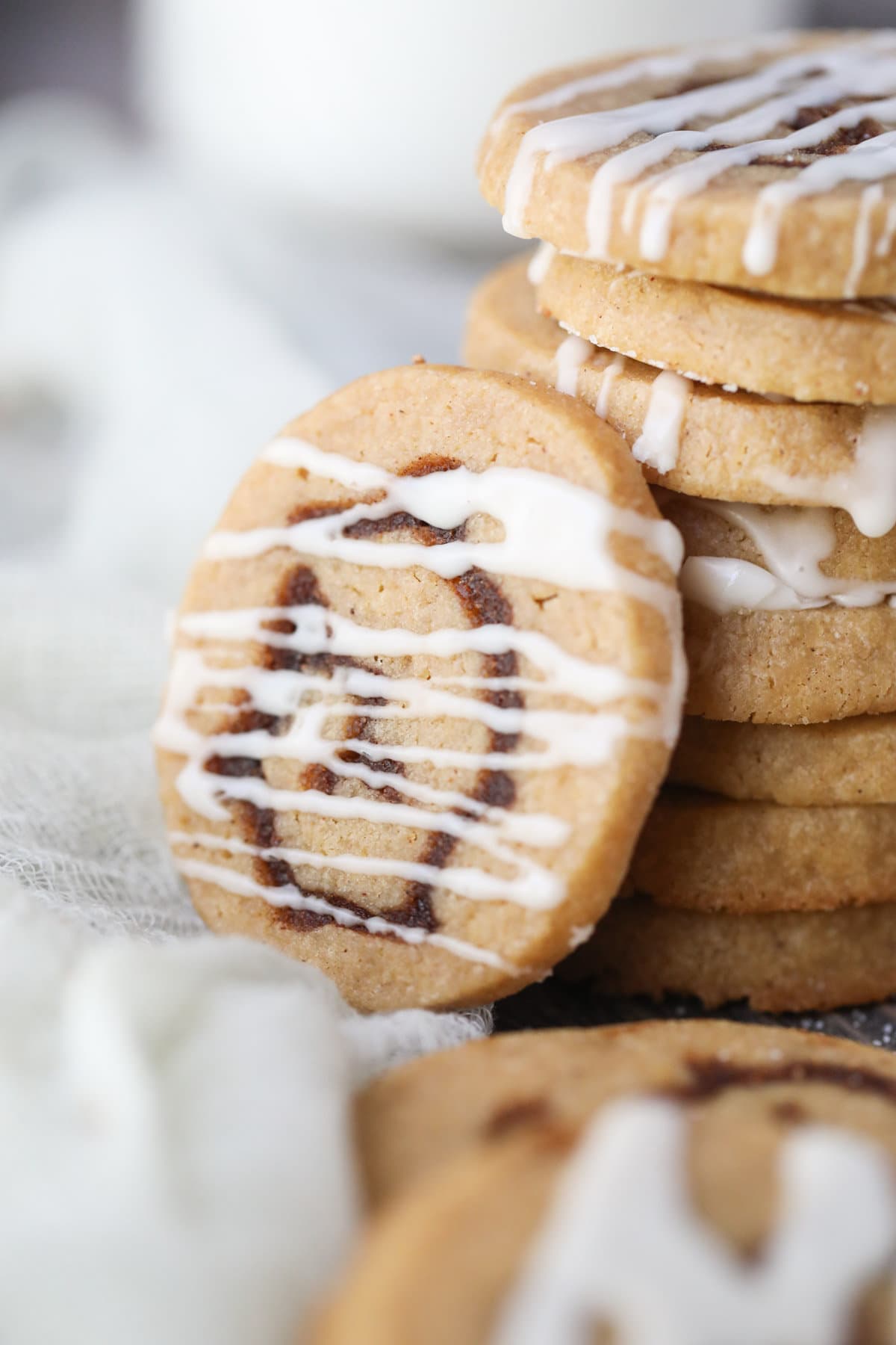 cinnamon roll cookie with vanilla glaze on a white surface.