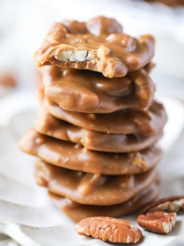 southern pecan pralines stacked on a white plate.