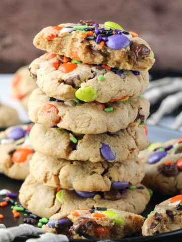 monster cookies stacked on a black plate.