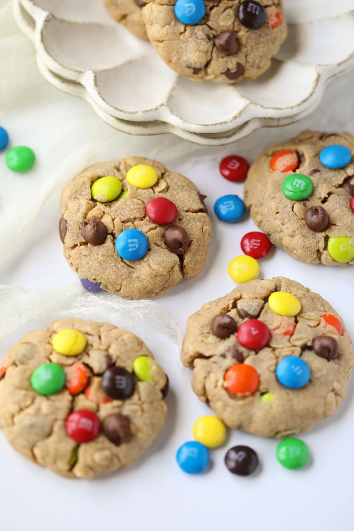 monster cookies scattered on a white table.