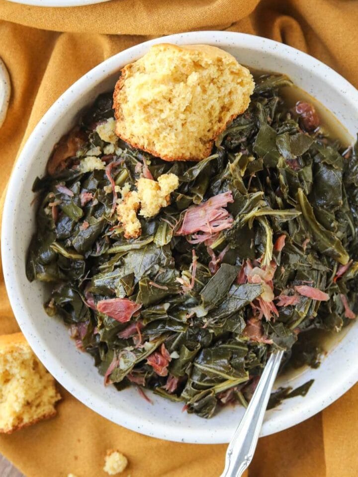 southern collard greens in a white bowl with cornbread.